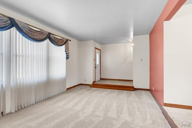 carpeted spare room with baseboards