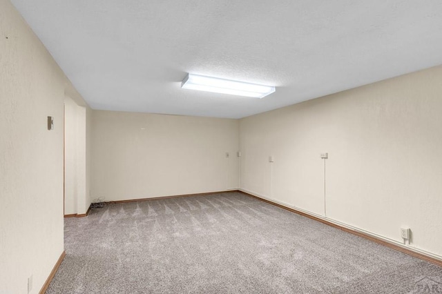 unfurnished room with a textured ceiling and carpet floors