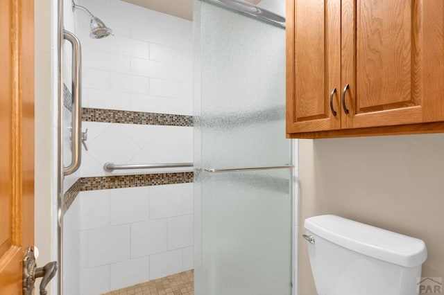 bathroom with a shower stall and toilet