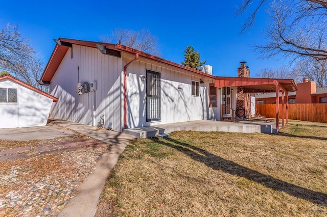 back of house with a patio area, fence, a lawn, and a chimney