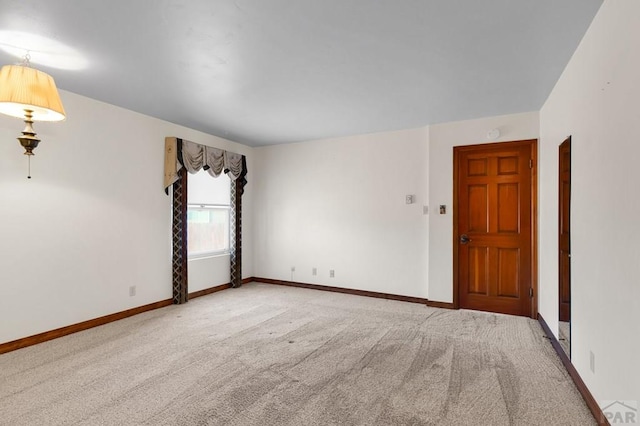 carpeted empty room featuring baseboards