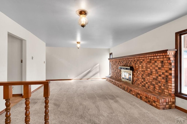 unfurnished living room with a fireplace, baseboards, and carpet floors