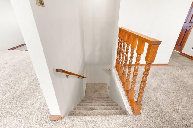 stairs featuring baseboards and carpet