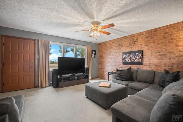 living room featuring light colored carpet, ceiling fan, a textured ceiling, and brick wall