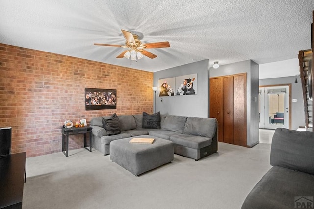 living room featuring light carpet, brick wall, and a textured ceiling