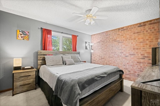 bedroom with a ceiling fan, light colored carpet, a textured ceiling, and brick wall