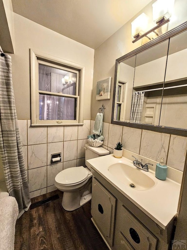 3112 Withers Ave, Pueblo, CO 81008 - full bathroom featuring tile walls, wood finished floors, vanity, toilet, and a shower with curtain