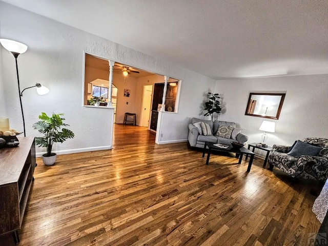 3112 Withers Ave, Pueblo, CO 81008 - living room featuring wood finished floors, baseboards, a ceiling fan, and a textured wall