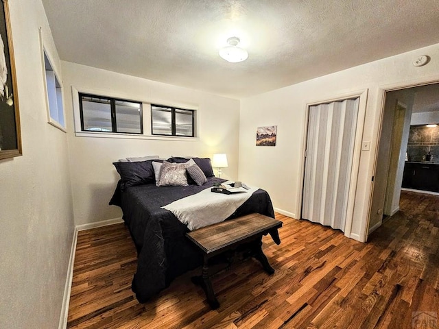 3112 Withers Ave, Pueblo, CO 81008 - bedroom featuring dark wood-style floors, baseboards, a textured ceiling, and a closet
