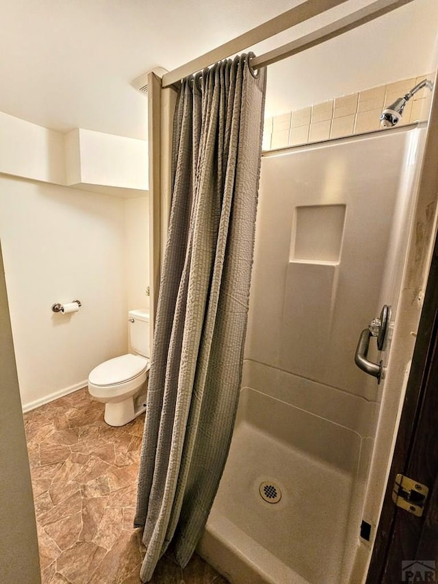 3112 Withers Ave, Pueblo, CO 81008 - full bath with a shower stall, toilet, baseboards, and stone finish floors