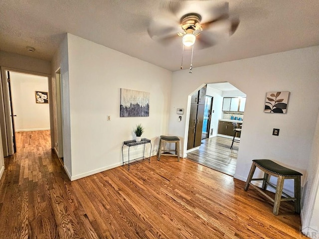 3112 Withers Ave, Pueblo, CO 81008 - corridor with arched walkways, wood finished floors, baseboards, and a textured ceiling