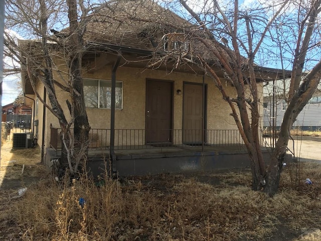 view of front of home with cooling unit and stucco siding