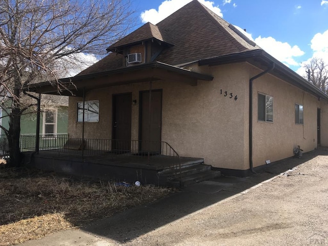 view of front of property with roof with shingles and stucco siding