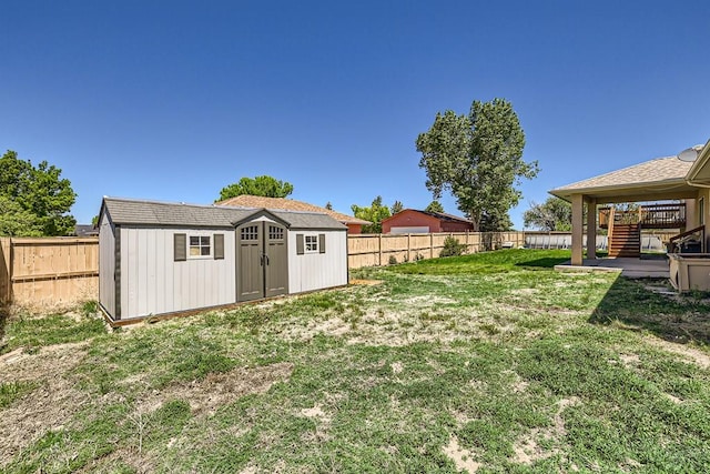 view of yard with a storage unit, a fenced backyard, and an outdoor structure