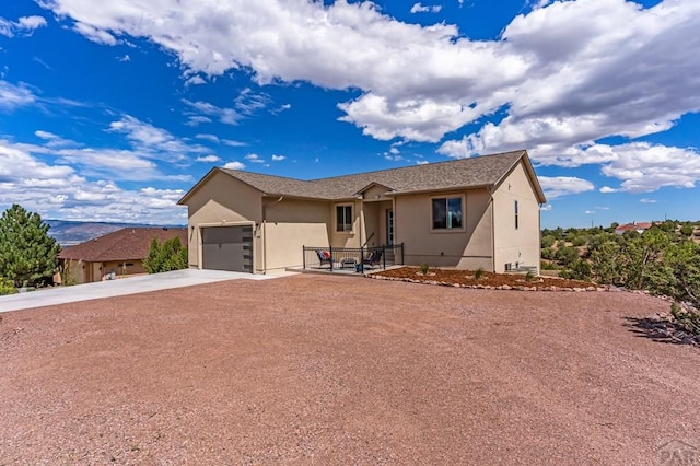 ranch-style house featuring a garage, concrete driveway, and stucco siding