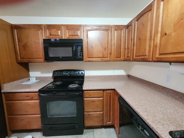 kitchen with brown cabinets, light countertops, and black appliances