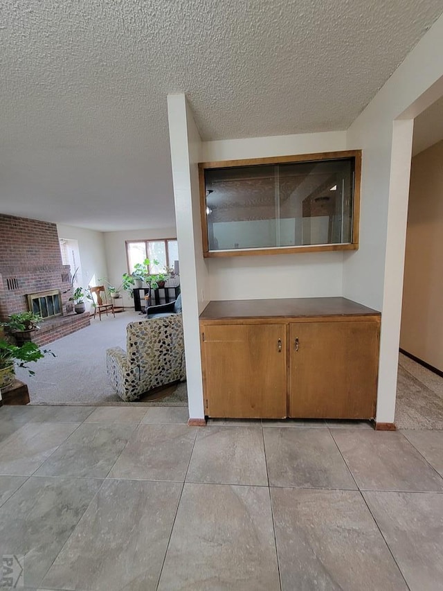 interior space with baseboards, a textured ceiling, and a fireplace
