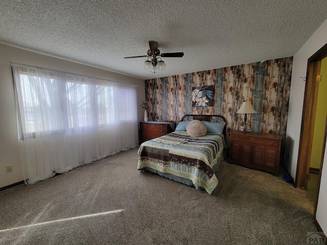carpeted bedroom featuring wood walls, ceiling fan, and a textured ceiling