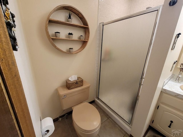 full bath with toilet, tile patterned floors, vanity, and a stall shower