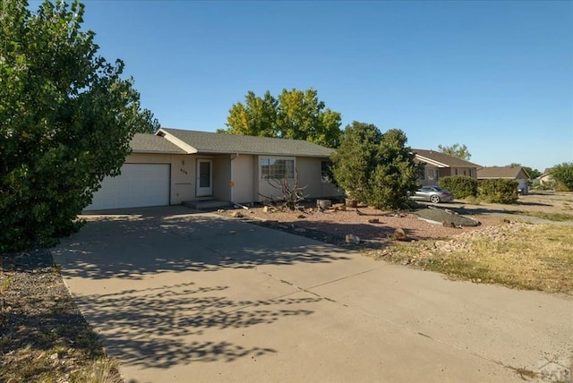 view of front of property with driveway, an attached garage, and stucco siding