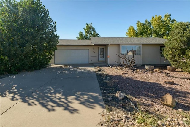 ranch-style home featuring an attached garage, concrete driveway, and stucco siding