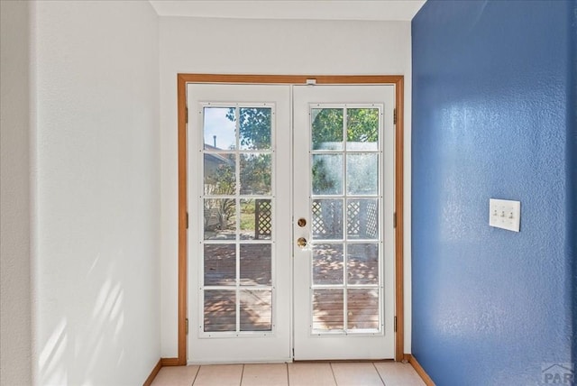 doorway featuring french doors, baseboards, and light tile patterned floors