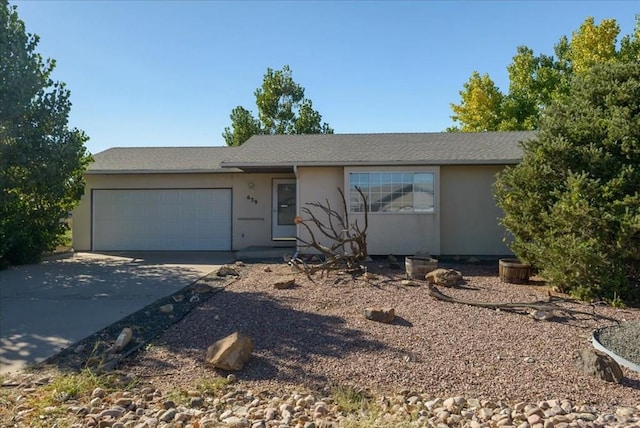 ranch-style home featuring concrete driveway, an attached garage, and stucco siding