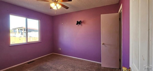 carpeted spare room featuring ceiling fan, visible vents, baseboards, and a textured ceiling