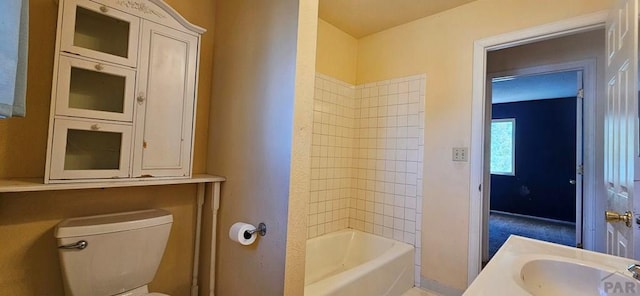 bathroom featuring bathing tub / shower combination, toilet, and vanity