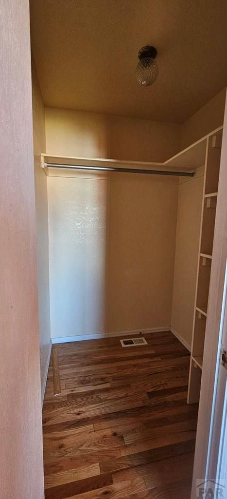 spacious closet with visible vents and dark wood finished floors