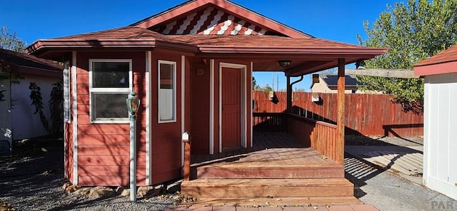 view of outbuilding featuring fence and an outbuilding