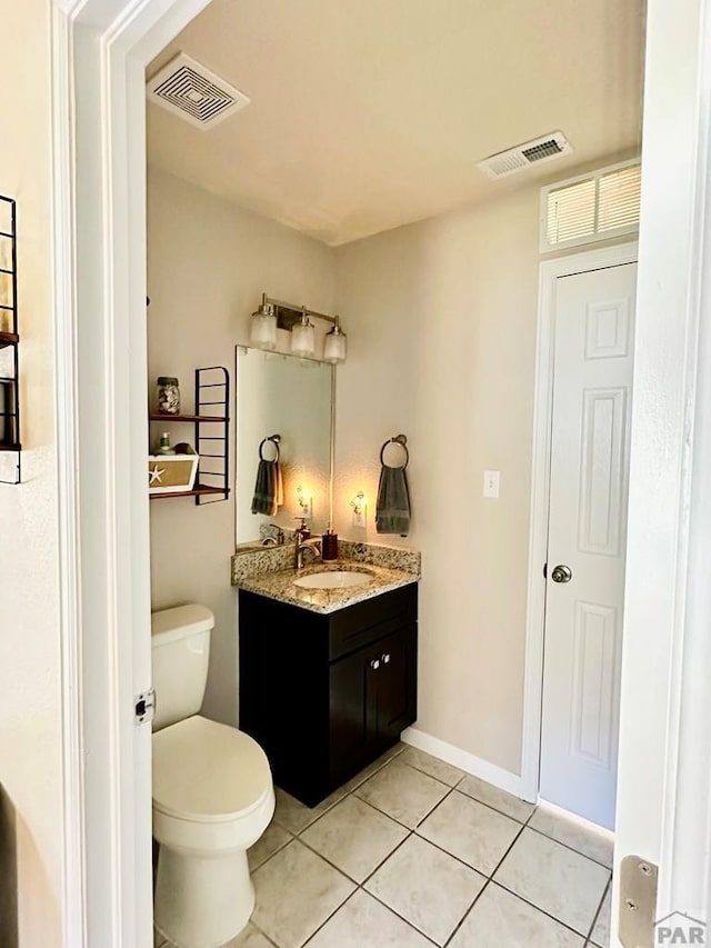 bathroom with visible vents, vanity, toilet, and tile patterned floors