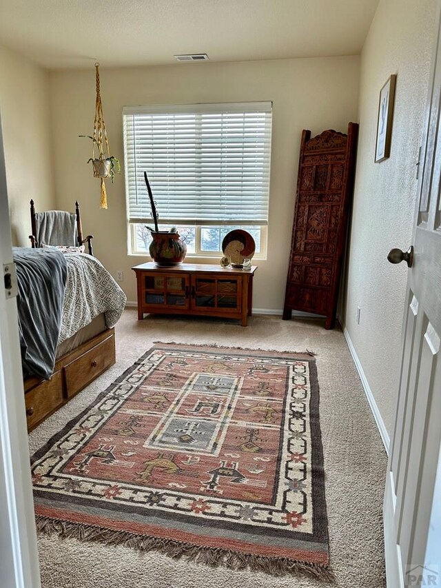 bedroom featuring multiple windows, visible vents, and light colored carpet