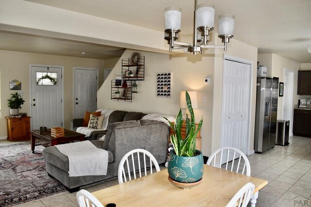 dining room with light tile patterned floors, stairs, and a chandelier