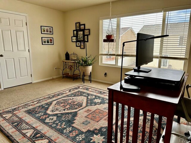 carpeted home office with baseboards