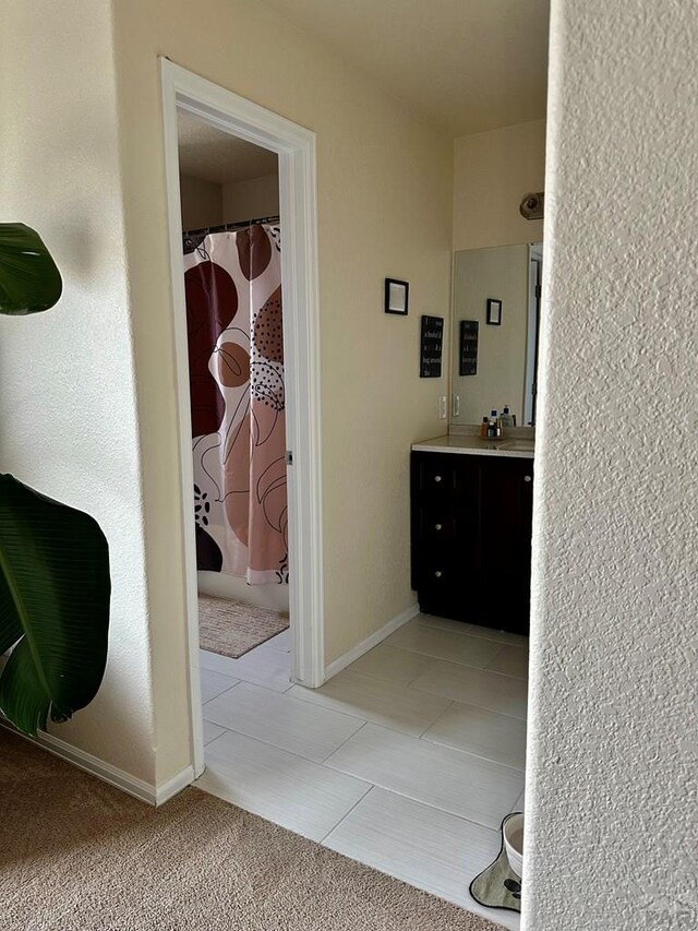 full bath featuring a shower with curtain, baseboards, and vanity