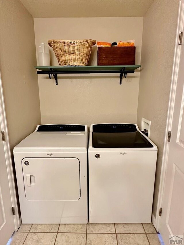 laundry area featuring light tile patterned floors, laundry area, and independent washer and dryer