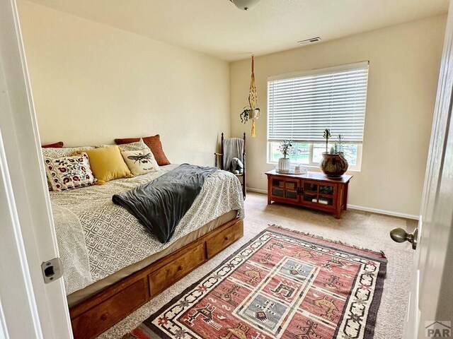 carpeted bedroom with baseboards and visible vents