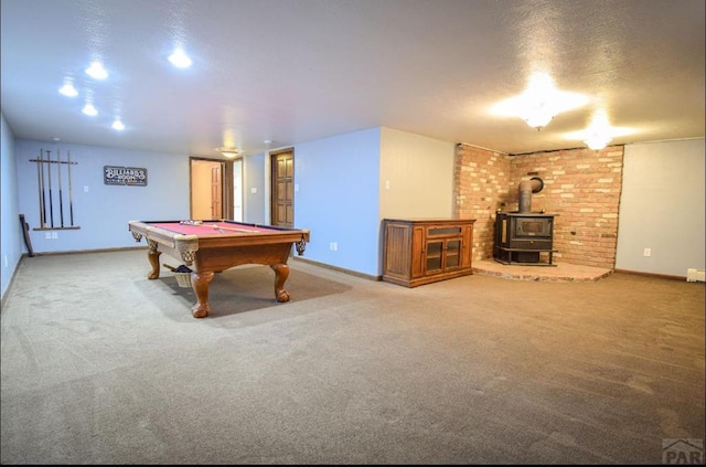 rec room with carpet floors, a wood stove, and baseboards