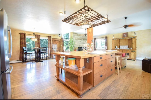 kitchen with lofted ceiling, ceiling fan, freestanding refrigerator, light wood-type flooring, and open shelves