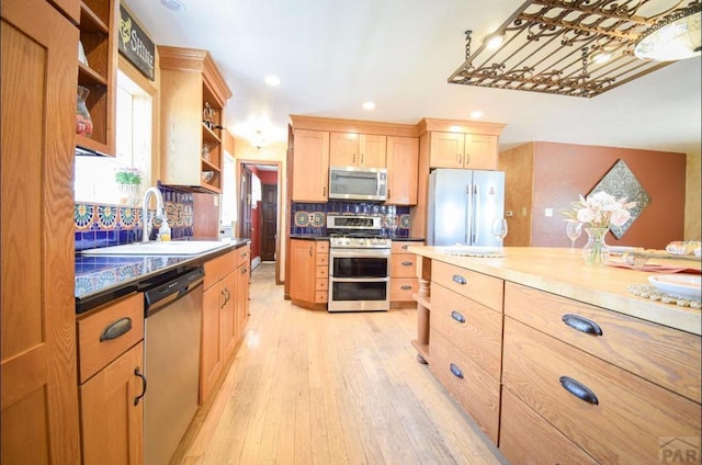 kitchen featuring tasteful backsplash, stainless steel appliances, light brown cabinets, open shelves, and a sink