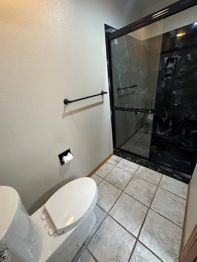 full bathroom with baseboards, toilet, and a stall shower