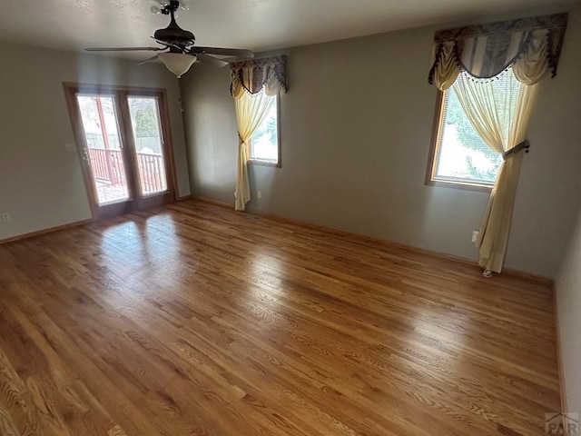 unfurnished room with wood finished floors and a ceiling fan