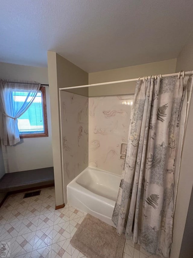 bathroom featuring visible vents, shower / bathtub combination with curtain, and a textured ceiling