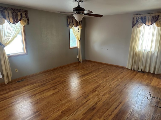 spare room with visible vents, ceiling fan, and wood finished floors