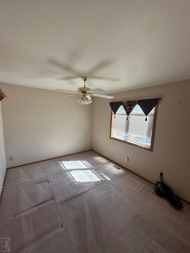 unfurnished room featuring light colored carpet and ceiling fan