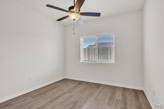 unfurnished room with light wood-style floors, baseboards, and a ceiling fan