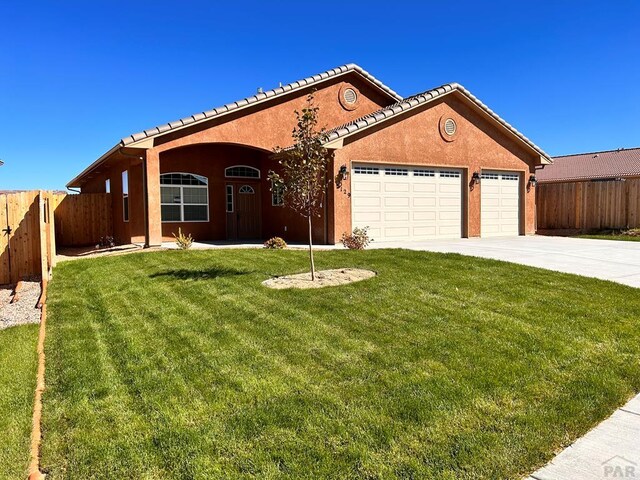 single story home with stucco siding, an attached garage, a front yard, fence, and driveway