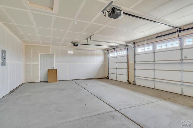 garage with electric panel and a garage door opener