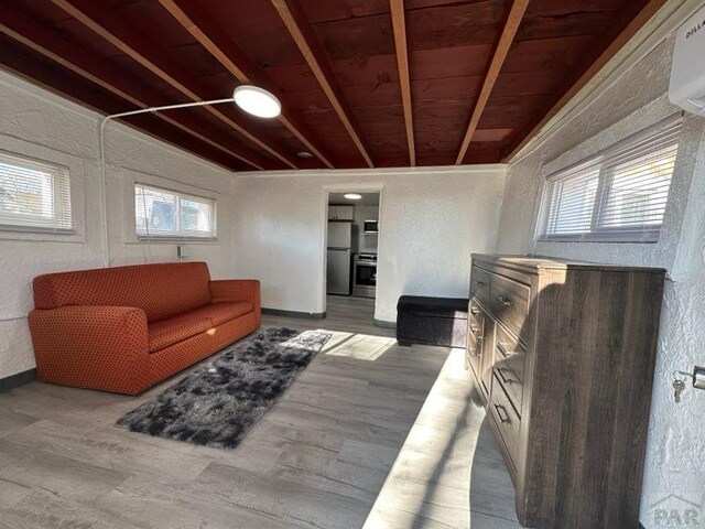 living room featuring wooden ceiling, light wood finished floors, plenty of natural light, and baseboards